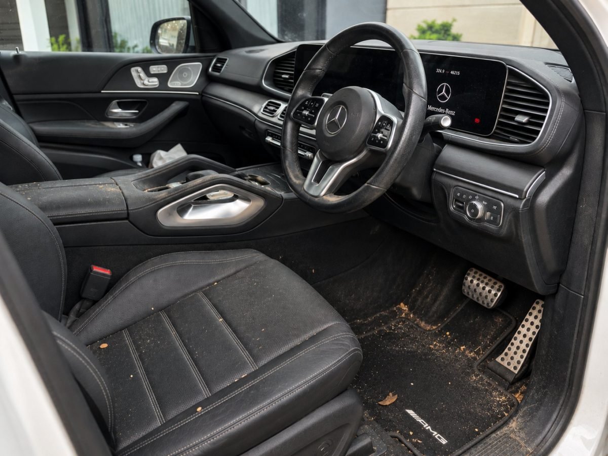The same Mercedes-Benz GLE cabin before detailing, with leaves and debris in the footwell